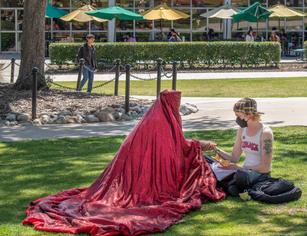 Red Chador interacting with a student on campus.