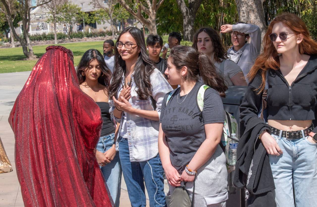 Red Chador interacting with students.