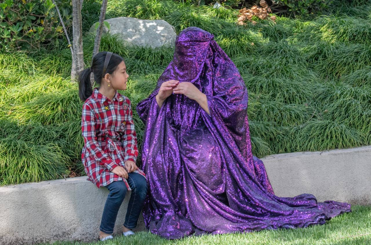 Purple Chador interacting with a young girl.