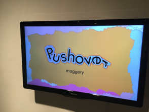 tv monitor that shows graphic design with text that reads 'Pushover' and below in smaller text reads 'Maggery'