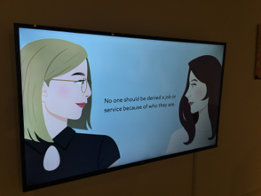 tv monitor showing a digital illustration of two women facing each other with text in between them