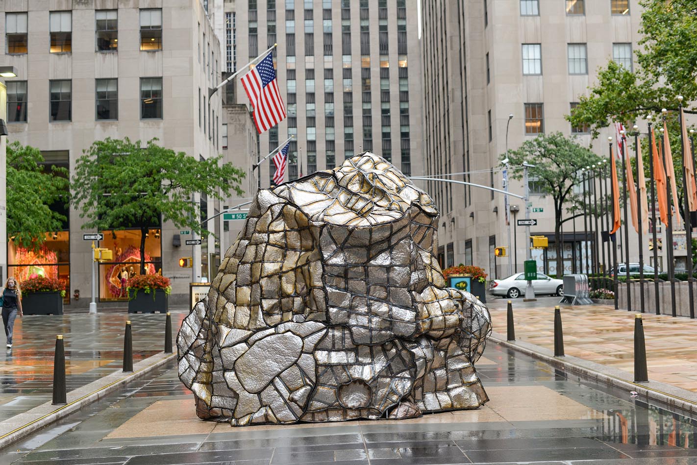 Organic, mound-like sculpture made on various slabs of metal in city setting.