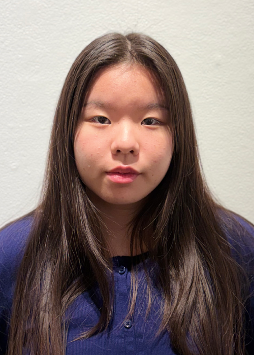Headshot of a young woman with long dark hair wearing a dark blue long sleeve.