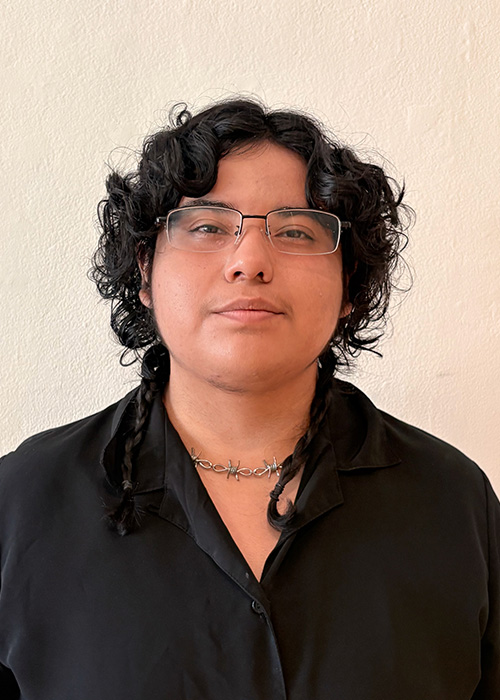 Headshot of a young man with short and curly black hair