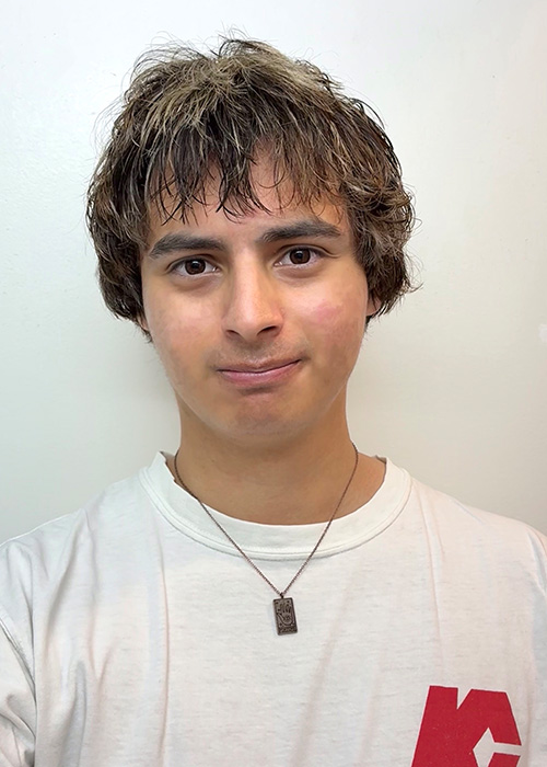 Headshot of a young man with short, curly, died brown hair 