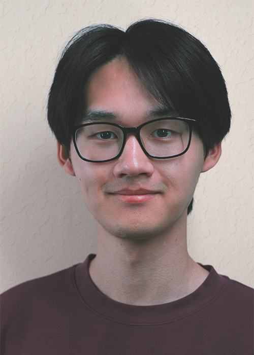 Headshot of a young man with short black hair, glasses, and a red shirt