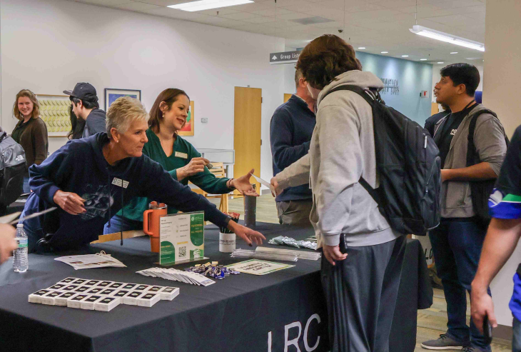 LRC staff members interact with a student at a table