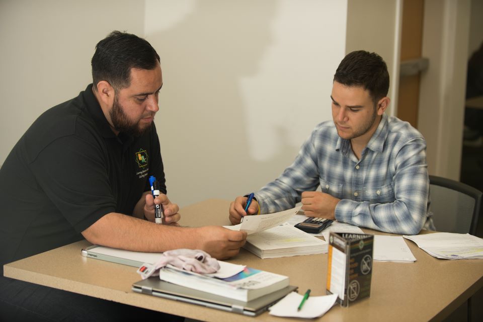 A tutor works with a student 