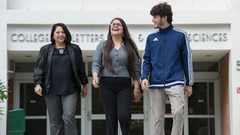 Dr. Garcia-Des Lauriers and two students walking towards the camera