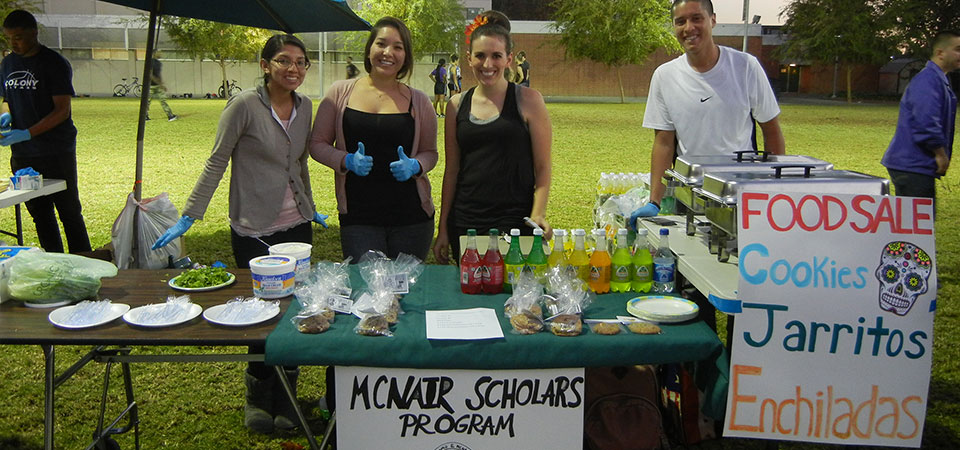 Students outdoors selling food at a stand