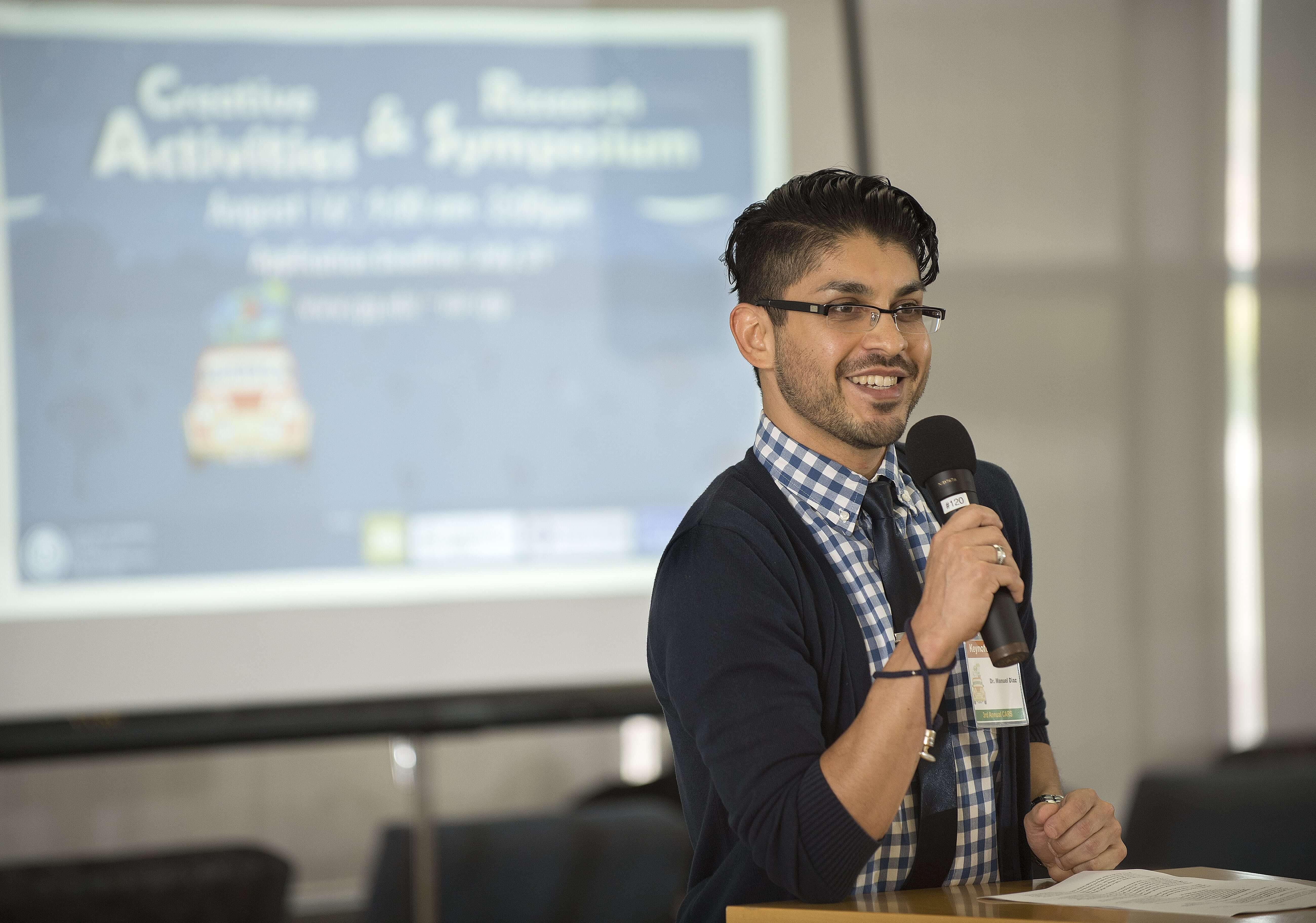 Faculty holding a microphone at research conference event