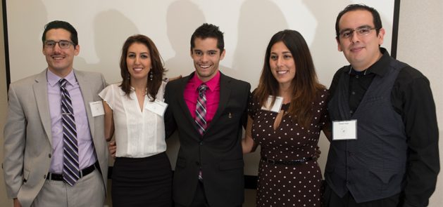 Five students in formal attire grouped together at conference