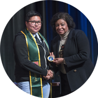 Veteran student being given medal by President Coley