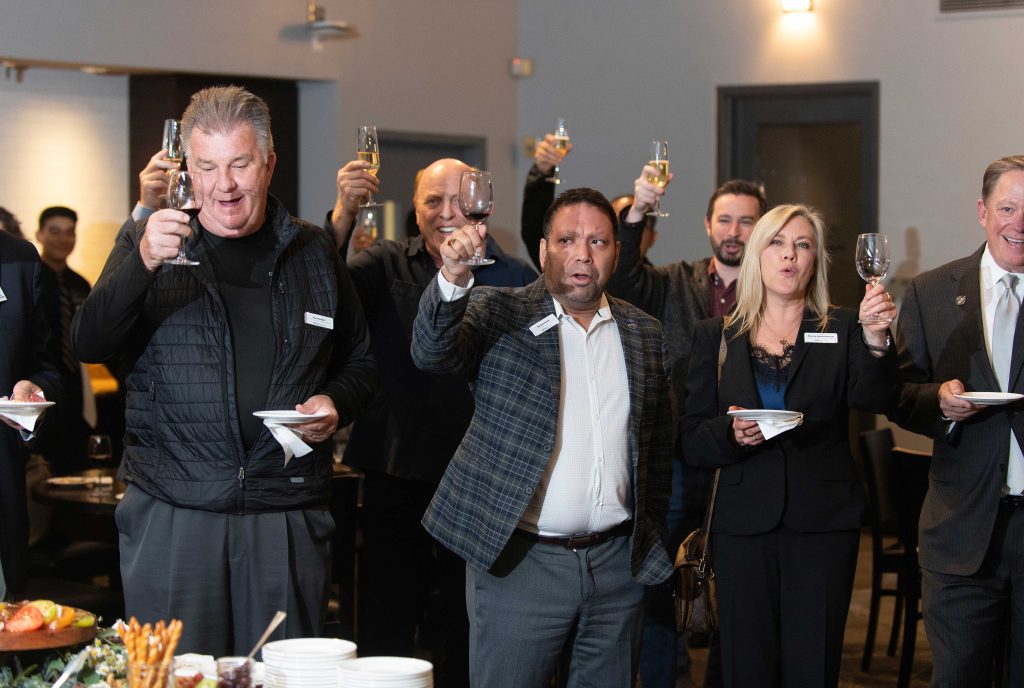 Group of people holding their wine glasses in a toast.