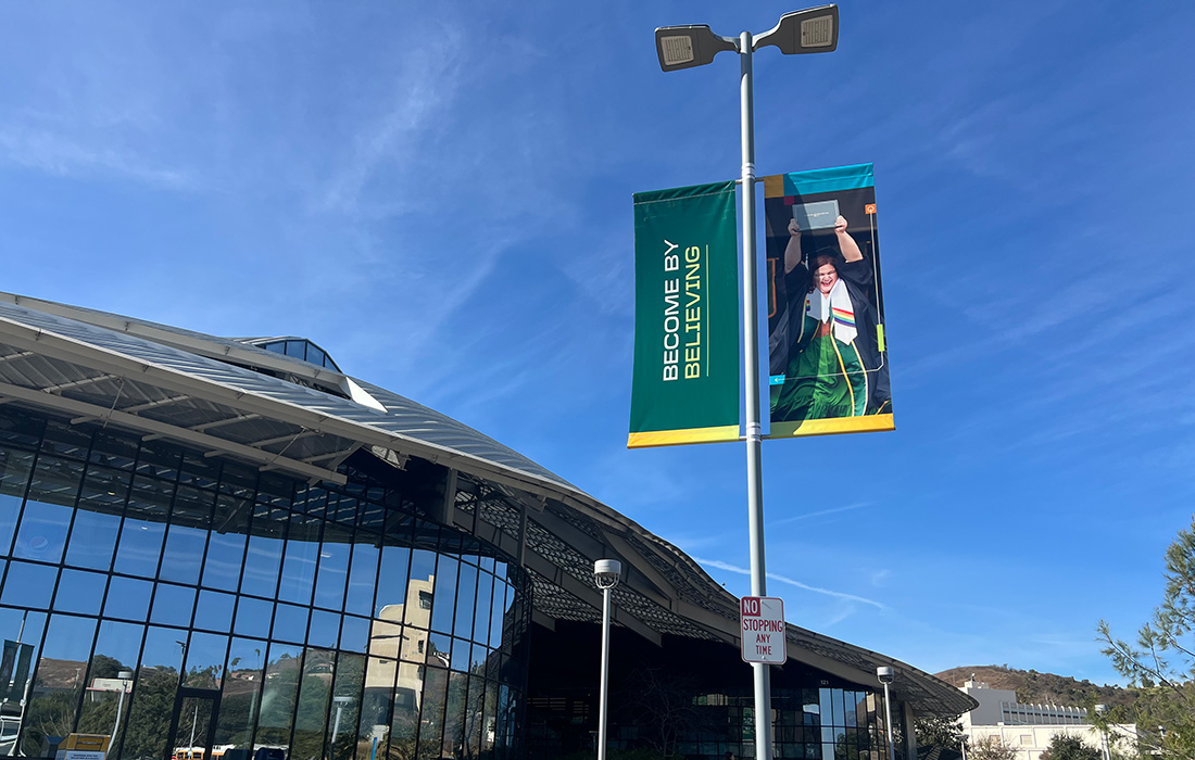 Light pole banner with Become by Doing branding.