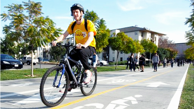 A bicyclist uses the new bike path from Lot B to the Bronco Student Center.