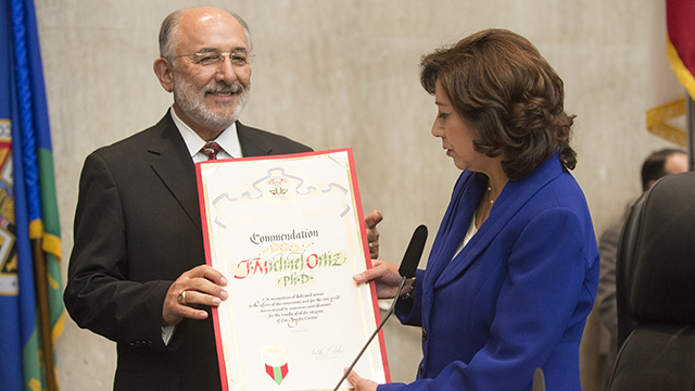 Cal Poly Pomona President Michael Ortiz receives a proclamation commending him for his lengthy career of outstanding service in higher education. Los Angeles County Supervisor Hilda Solis, an alumna and former scholar-in-residence, presented Ortiz with the proclamation.