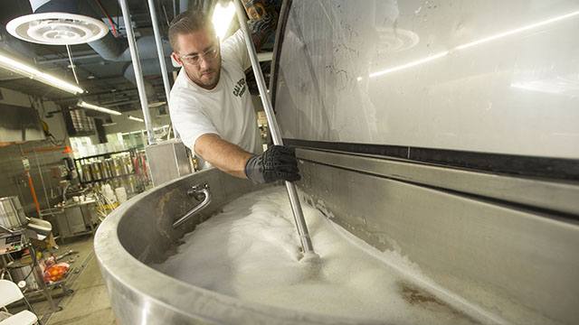 Richard Thompson stirs a grain mixture that will eventually become an orange wheat beer at Innovation Brew Works.