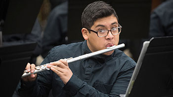 Student plays the flute during the recording of a music video at Gary High School.