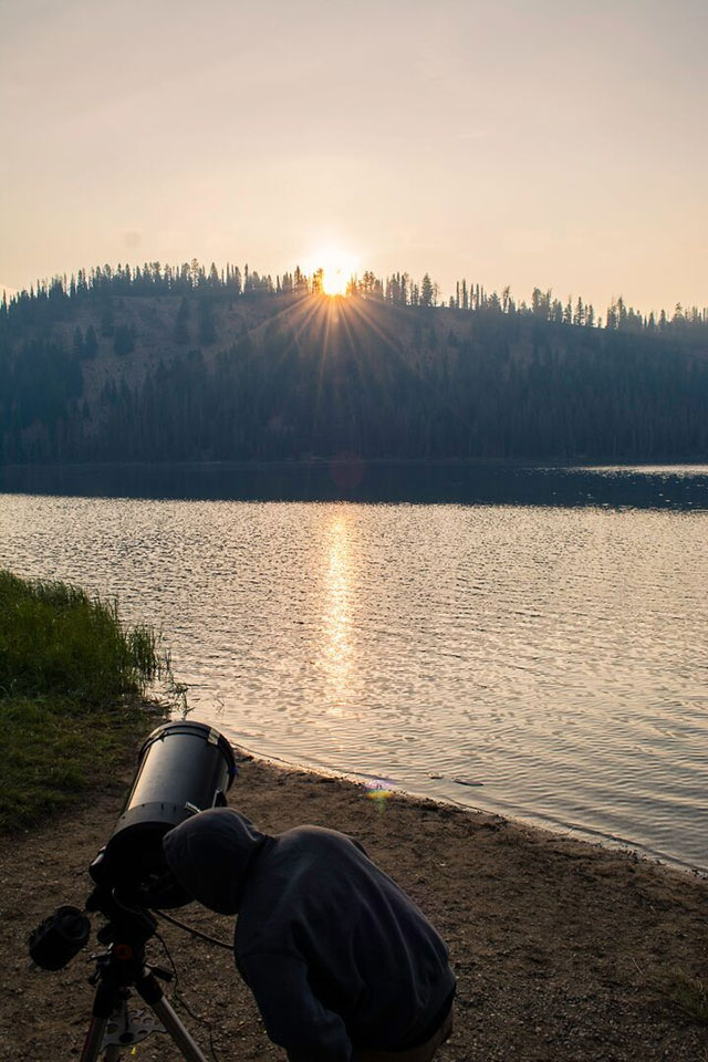 Student aligns the telescope at dawn on the morning of the eclipse. Photo by Christopher Mendoza, a senior majoring in physics.