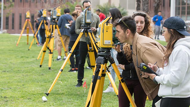Students take measurements during their advanced surveying course in the Engineering Meadow.