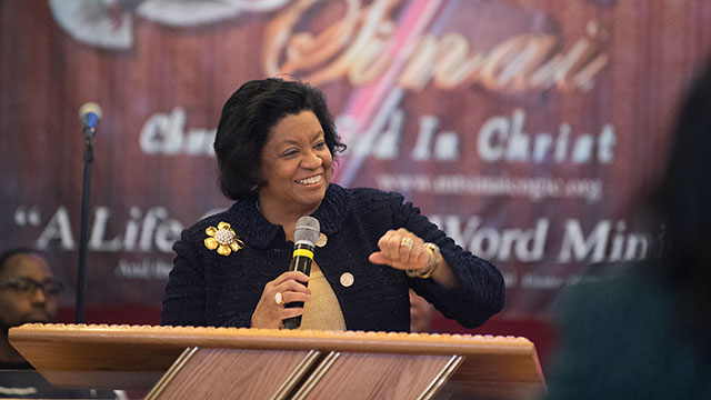 President Coley smiles at a pulpit while speaking during Super Sunday.
