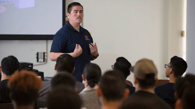 Reggie Robles speaks to a group of students.