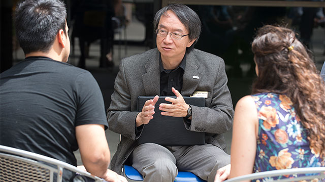 Henry Woo speaks to a couple of people.