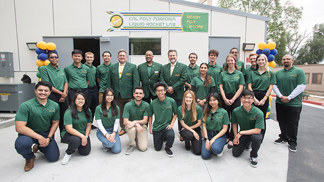 A group poses in front of the Liquid Rocket Lab during opening ceremony.