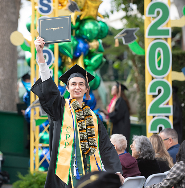 A college of Business Graduate showing his diploma.