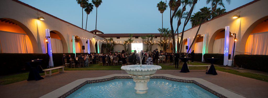 Old stables fountain with guests seated at tables behind it during the Alumni Awards Gala. 