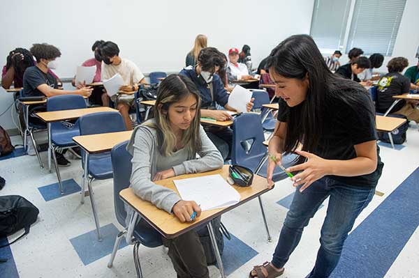 Laura Hu, a senior math major, helps Bronco Scholar Emily Garcia with a math problem.