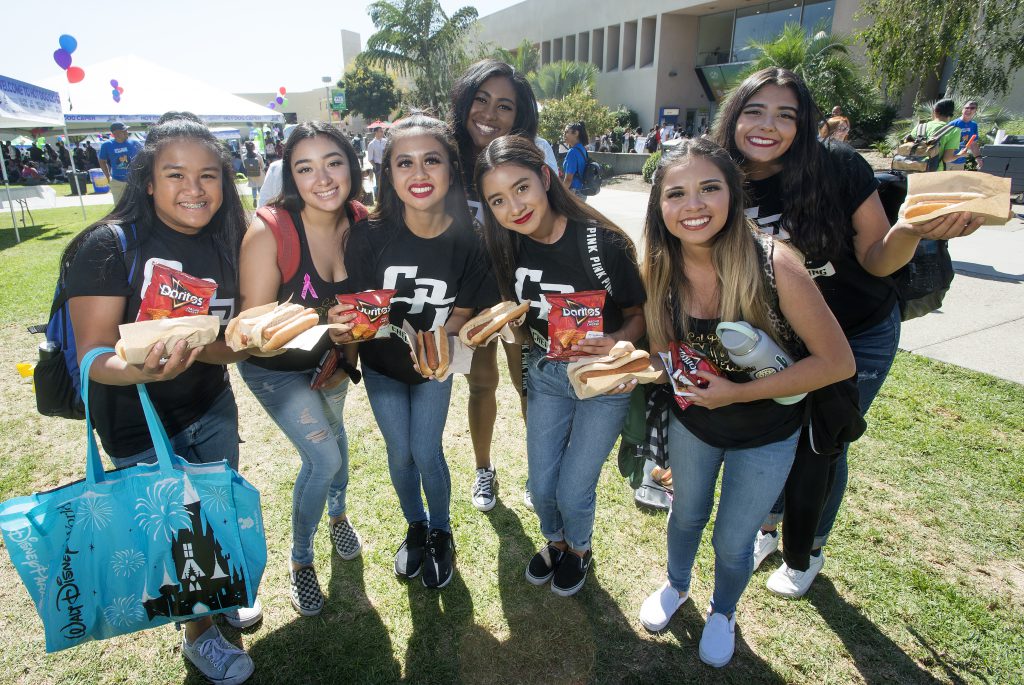 A group of female students pose for a photo holding hot dogs during the 2019 Hot Dog Caper
