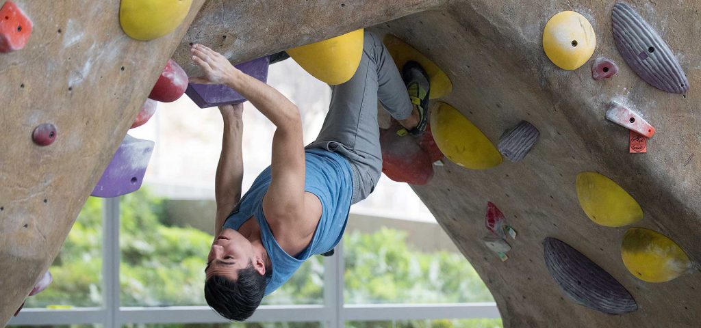 Male Student climbs the rock wall at the BRIC.