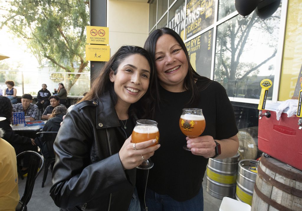 Two people drink beer during the Brew Works Anniversary. 
