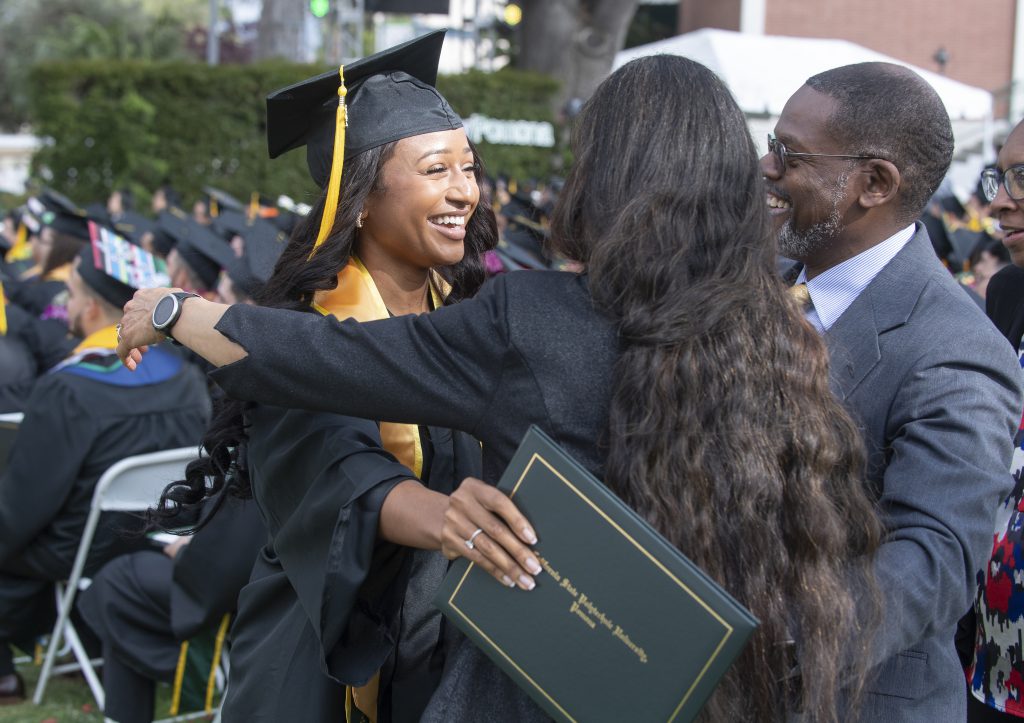 A female graduate hugs her family during the College of Science Commencement Cermonies