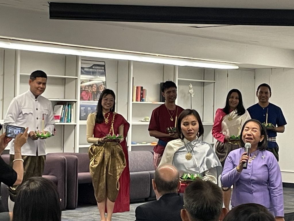 People holding candles and smiling during a presentation.