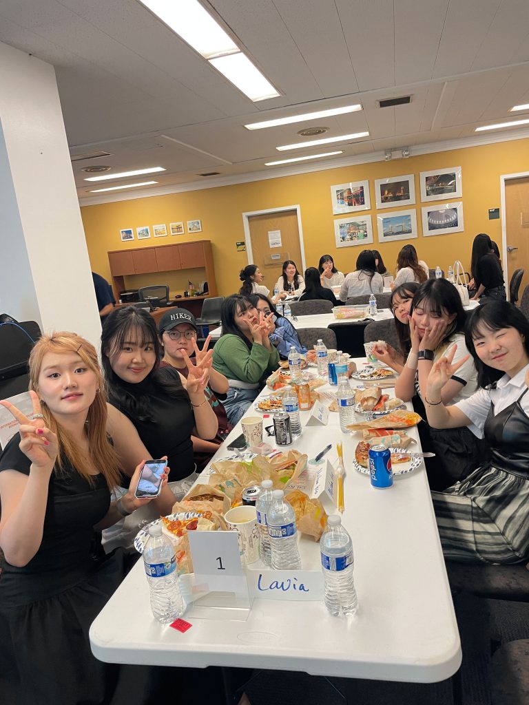 A group of Korean exchange students smile during lunch.