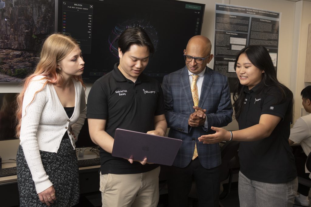 Dean Sandeep Krishnamurthy with cyber students at the College of Business Administration.
