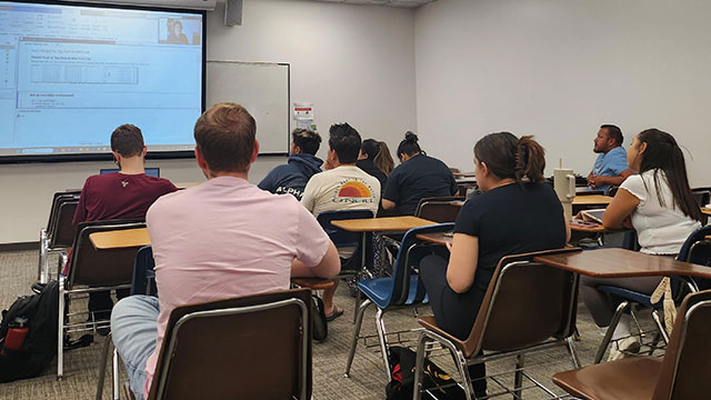 Students in a class listen to a presentation