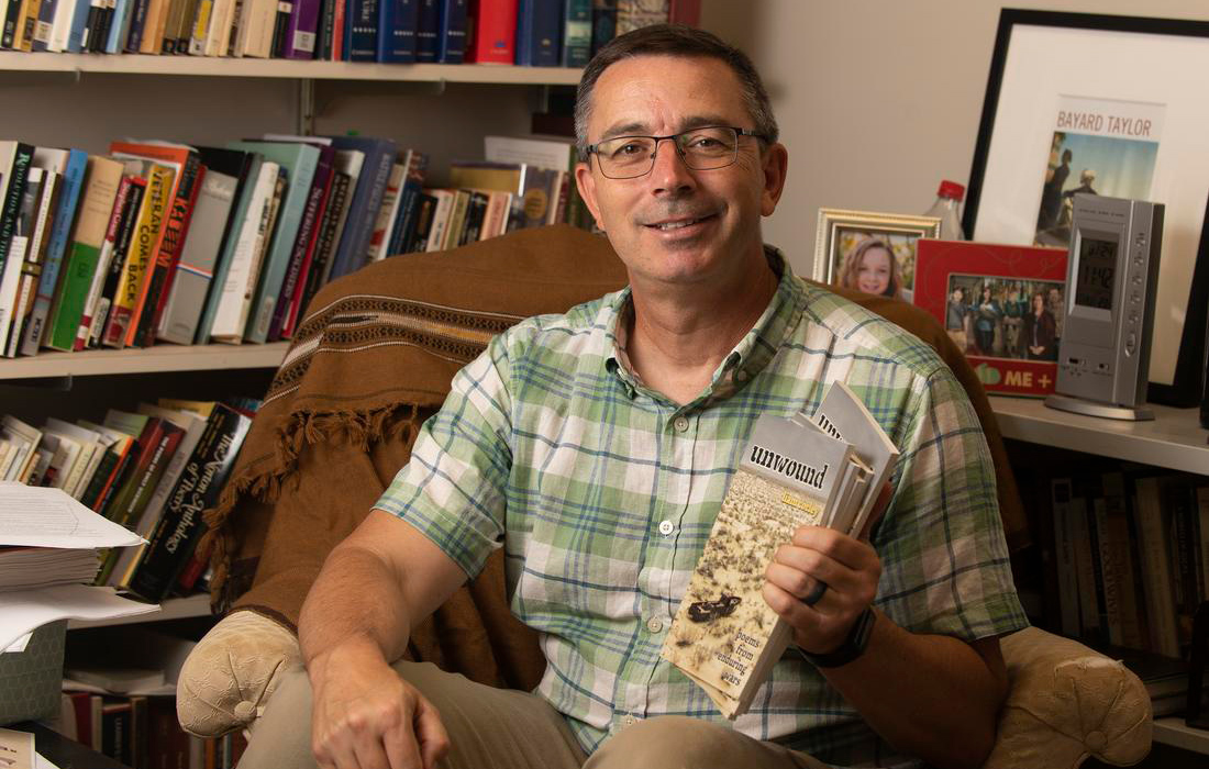 Liam Corley holding his book "Unwound"
