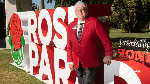 Alex Aghajanian in front of Rose Parade sign.