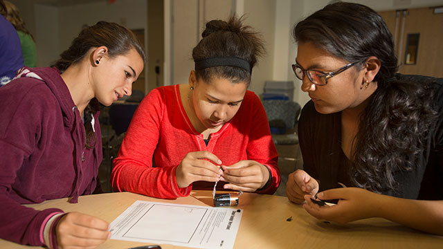Piper Zimmerman, Kayla Shirley and Divya Ramanand from University Prep High School create a flash light from a battery, foil and tape as part of Y.E.S.! Program put on by the Cal Poly Pomona Society of Women Engineers.