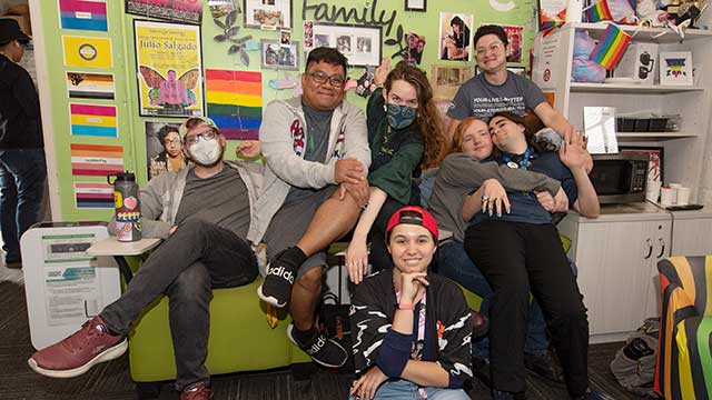 A group of students pose for a photo in the Pride Center.