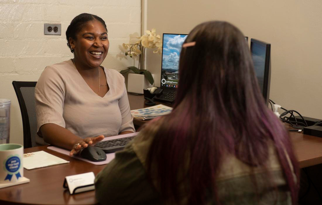 Nicole Turner talking with a female student in her office.