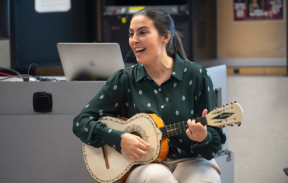 Jesse Vallejo plays guitar and sings to her students. 
