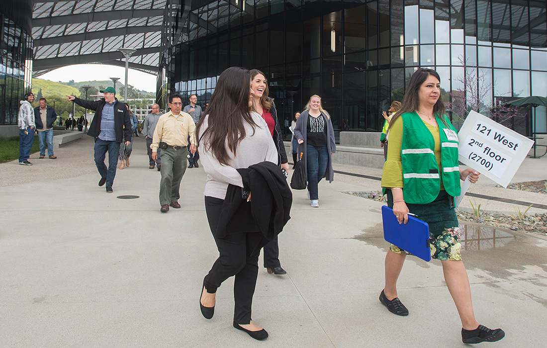 Staff members emerge from the Student Services Building during an evacuation drill.