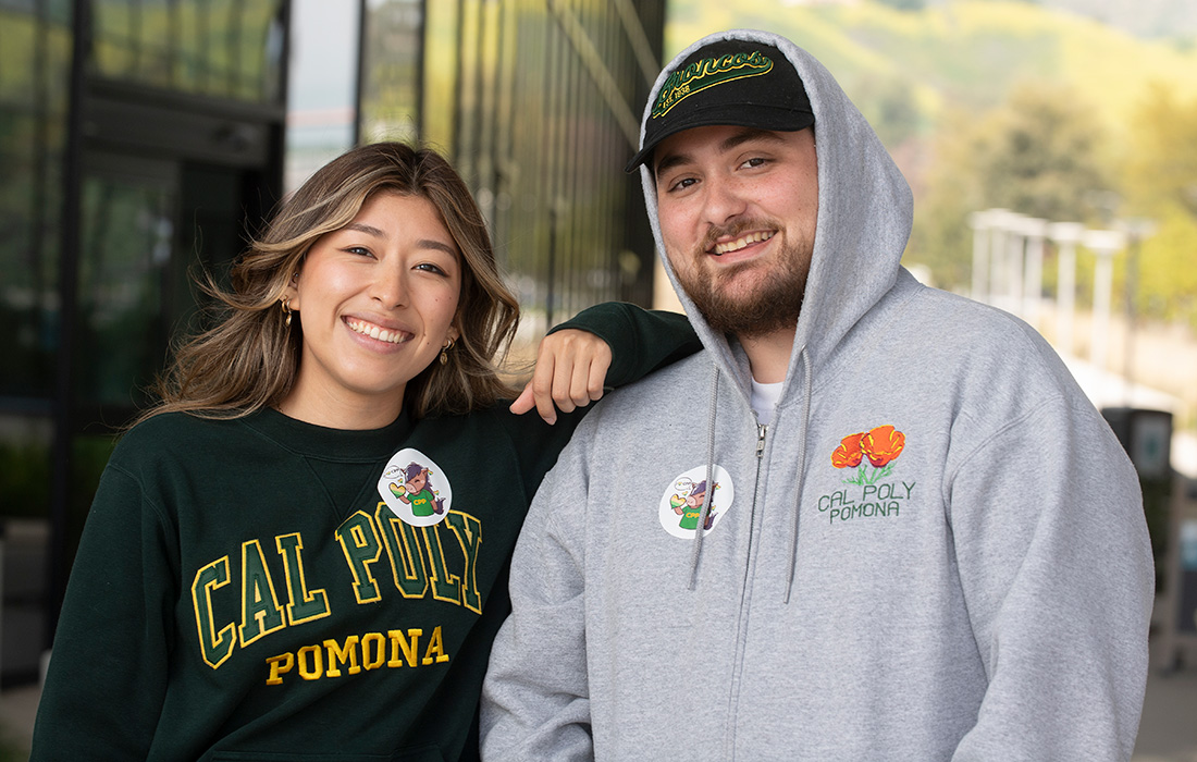 Two students smile while wearing Giving Day stickers.