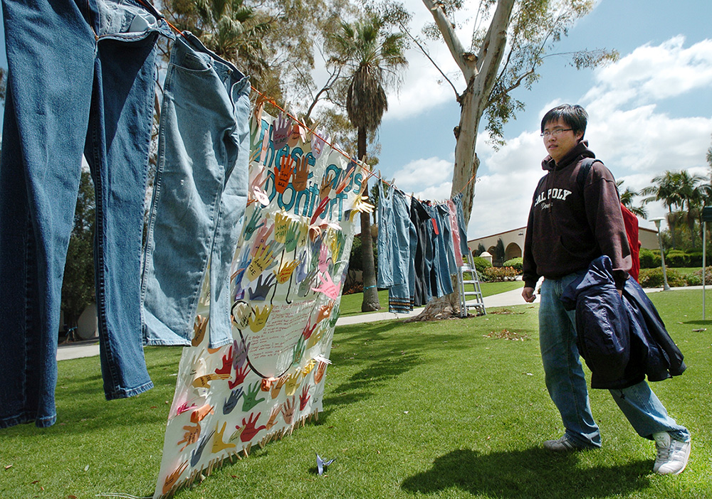 A student looks at a display of blue jeans for Denim Day, an event raising awareness about sexual violence.