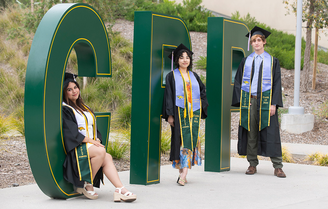 Three students pose for a photo on the CPP Letters at the Park at 98.